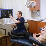 Dr. Howard pointing to x ray with female patient